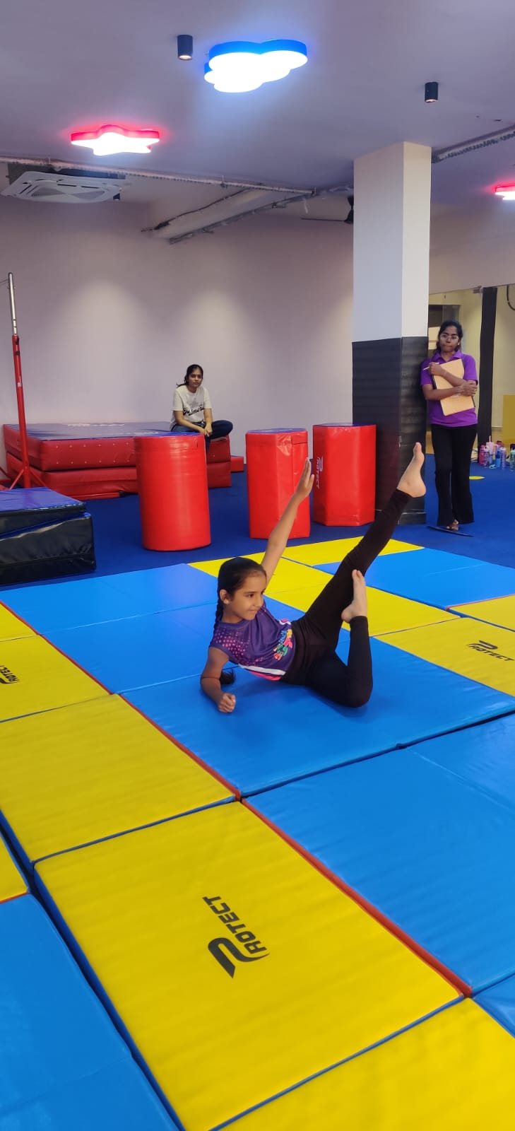 Young gymnast practising a flexibility pose on the gym mat