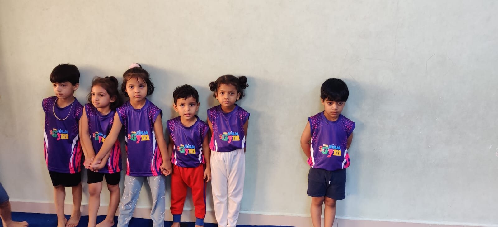 Young children in Little Ninja Gym uniforms standing together in class